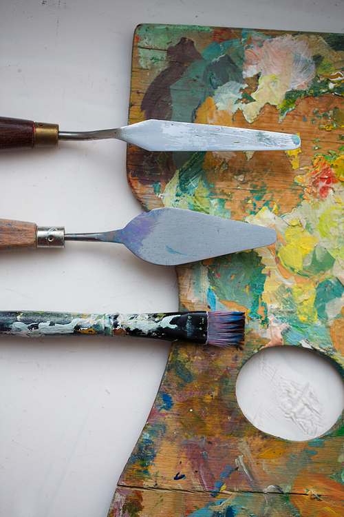 fine art, creativity and artistic tools concept - close up of palette knives or painting spatulas and paintbrush from top