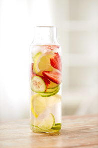 healthy eating, drinks and detox concept - close up of fruit water or ice tea in glass bottle
