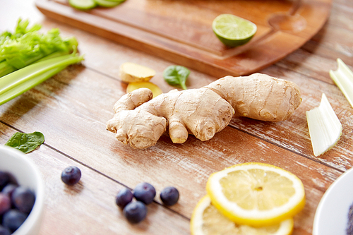 healthy eating, food and  concept - ginger with fruits, berries and vegetables on table