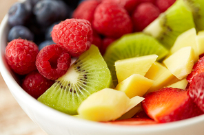healthy eating and food concept - close up of fruits and berries in bowl