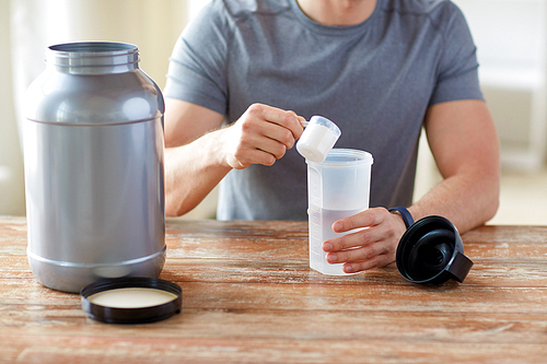 sport, healthy lifestyle and people concept - close up of man wearing fitness tracker with jar and bottle preparing protein shake