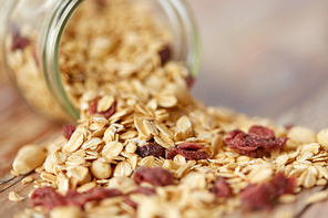 food, healthy eating and diet concept - close up of jar with granola or muesli poured on table