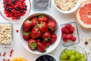 healthy eating and food concept - fruits and berries in bowls on table