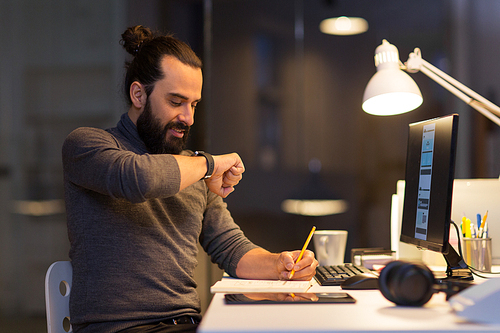deadline, technology and people concept - creative man with smartwatch using voice command recorder and working late at night office