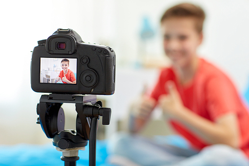 blogging, technology and people concept - camera recording video of happy smiling . boy showing thumbs up at home