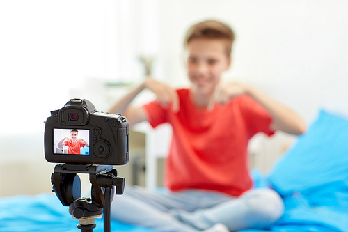 blogging, technology and people concept - camera recording video of happy smiling . boy at home