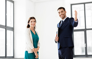 real estate business, sale and people concept - happy smiling realtor with folder showing new office room to female customer