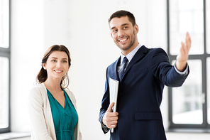 real estate business, sale and people concept - happy smiling realtor with folder showing new office room to female customer