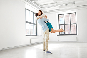 mortgage, people and real estate concept - happy couple hugging at new home