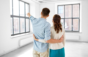 mortgage, people and real estate concept - happy couple hugging at new home from back