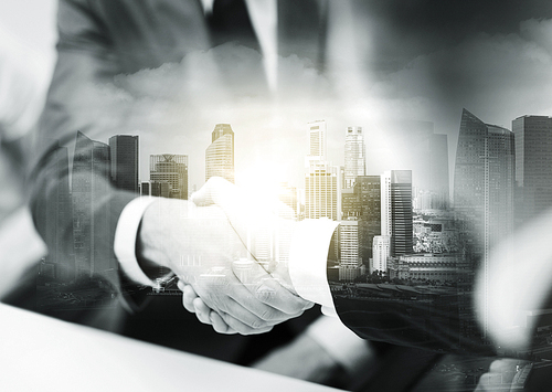 business, cooperation, partnership and people concept - two businessmen shaking hands at office over city buildings and double exposure effect