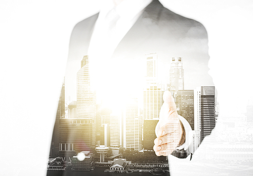 people, business and partnership concept - businessman hand ready for handshake over city with double exposure