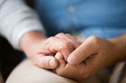 relationships, charity, old age and people concept - close up of senior couple holding hands