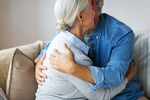 relationships, old age and people concept - close up of happy senior couple hugging at home