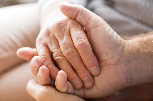 relationships, marriage and old people concept - close up of senior couple holding hands