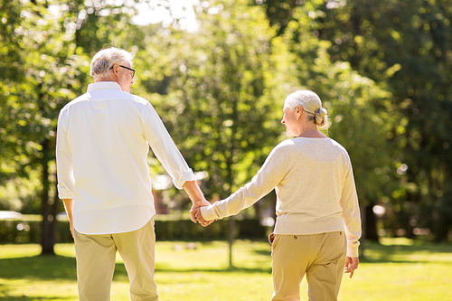 old age, relationship and people concept - happy senior couple walking at summer park