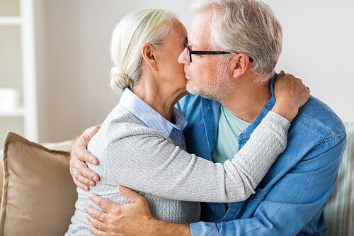 relationships, old age and people concept - close up of happy senior couple hugging and kissing at home