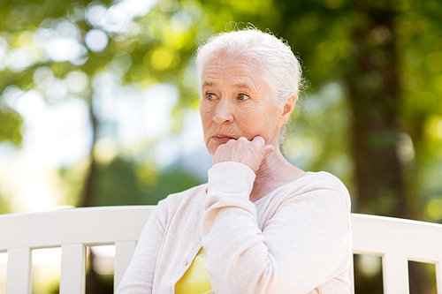 old age, retirement and people concept - sad senior woman sitting on bench at summer park