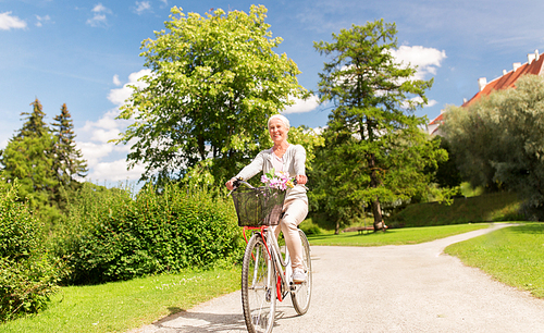 active old age, people and lifestyle concept - happy senior woman riding fixie bicycle at summer park