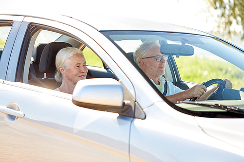 road trip, travel and old people concept - happy senior couple driving in car