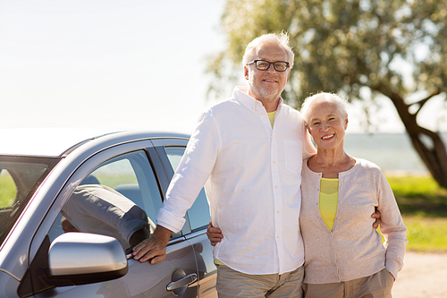 road trip, travel and old people concept - happy senior couple with car in summer