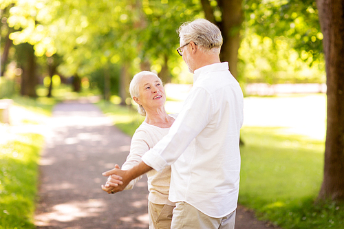 old age, relationship and people concept - happy senior couple dancing waltz at summer park