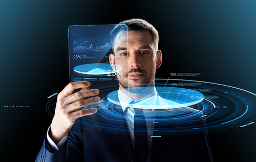 business, augmented reality and future technology concept - businessman in suit working with transparent tablet pc computer and virtual charts projections over black background