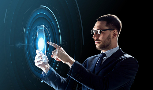 business, augmented reality and future technology concept - businessman in glasses working with transparent tablet pc computer and hologram over black background