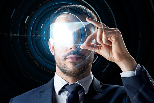 business, augmented reality and future technology concept - businessman in suit working with transparent smartphone and hologram over black background