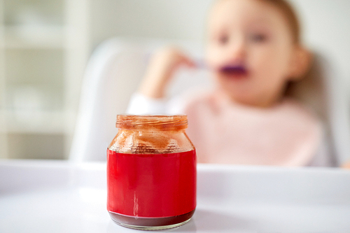 child, feeding and people concept - jar of baby food on table at home