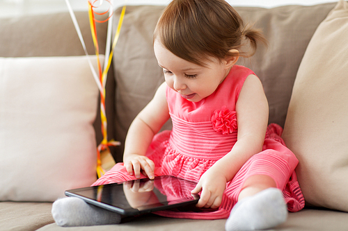 childhood, people and technology concept - happy baby girl with tablet pc computer at home
