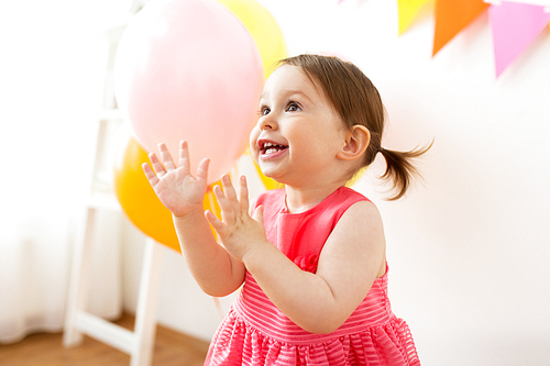childhood, people and celebration concept - happy baby girl on birthday party at home