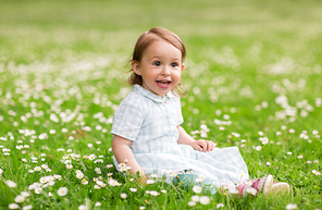 childhood, leisure and people concept - happy baby girl on green summer field
