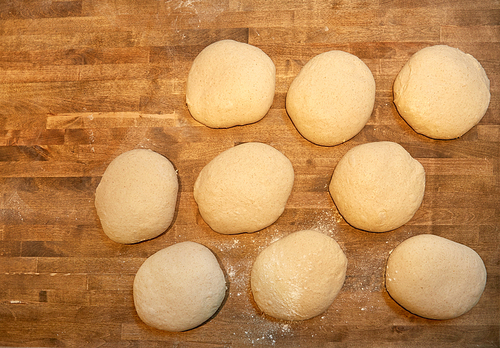 food, cooking and baking concept - yeast bread dough rising on bakery kitchen table