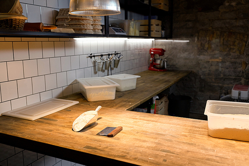 food, cooking and baking concept - dough, bakery scoop with flour and bench cutter on wooden kitchen table