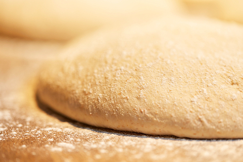food, cooking and baking concept - close up of yeast bread dough rising at bakery