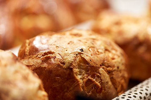 food, cooking and baking concept - close up of yeast bread, bun or pie at bakery