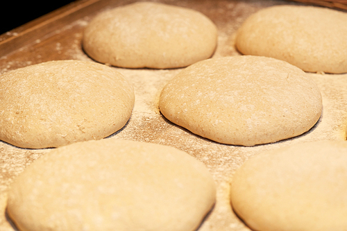 food, cooking and baking concept - yeast bread dough rising on bakery kitchen table