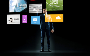 business, people and technology concept - businessman in suit working with virtual applications over black background