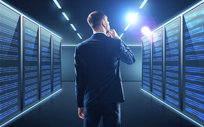 business, people and technology concept - businessman in suit over server room background