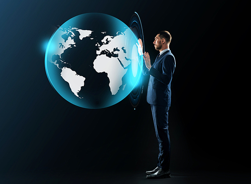 business, people and technology concept - businessman in suit working with virtual earth projection over black background