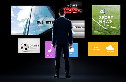 business, people and technology concept - businessman in suit with virtual applications over black background