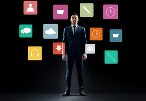 business, people and technology concept - businessman in suit with virtual menu icons over black background