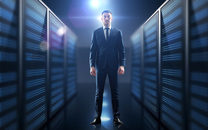business, people and technology concept - businessman in suit over server room background