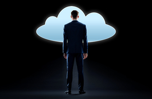 business, people and technology concept - businessman in suit looking at virtual cloud hologram over black background