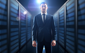 business, people and technology concept - businessman in suit over server room background