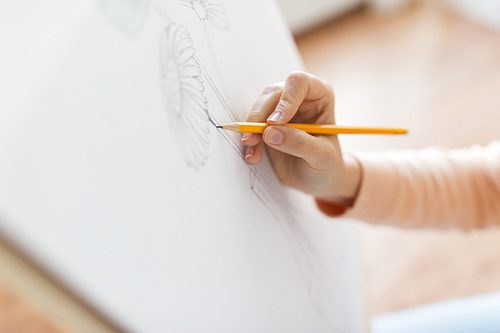 art, creativity and people concept - artist hands with graphite pencil drawing still life picture of flower in vase on paper at studio