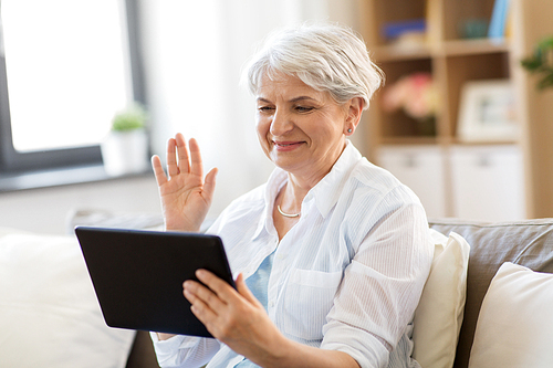 technology, people and communication concept - happy senior woman with tablet pc computer having video chat at home