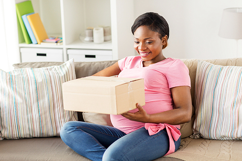 delivery, people and pregnancy concept - happy pregnant african american woman with parcel box at home