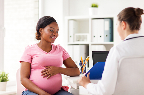 pregnancy, medicine, healthcare and people concept - gynecologist doctor with clipboard and happy pregnant african american woman meeting at hospital